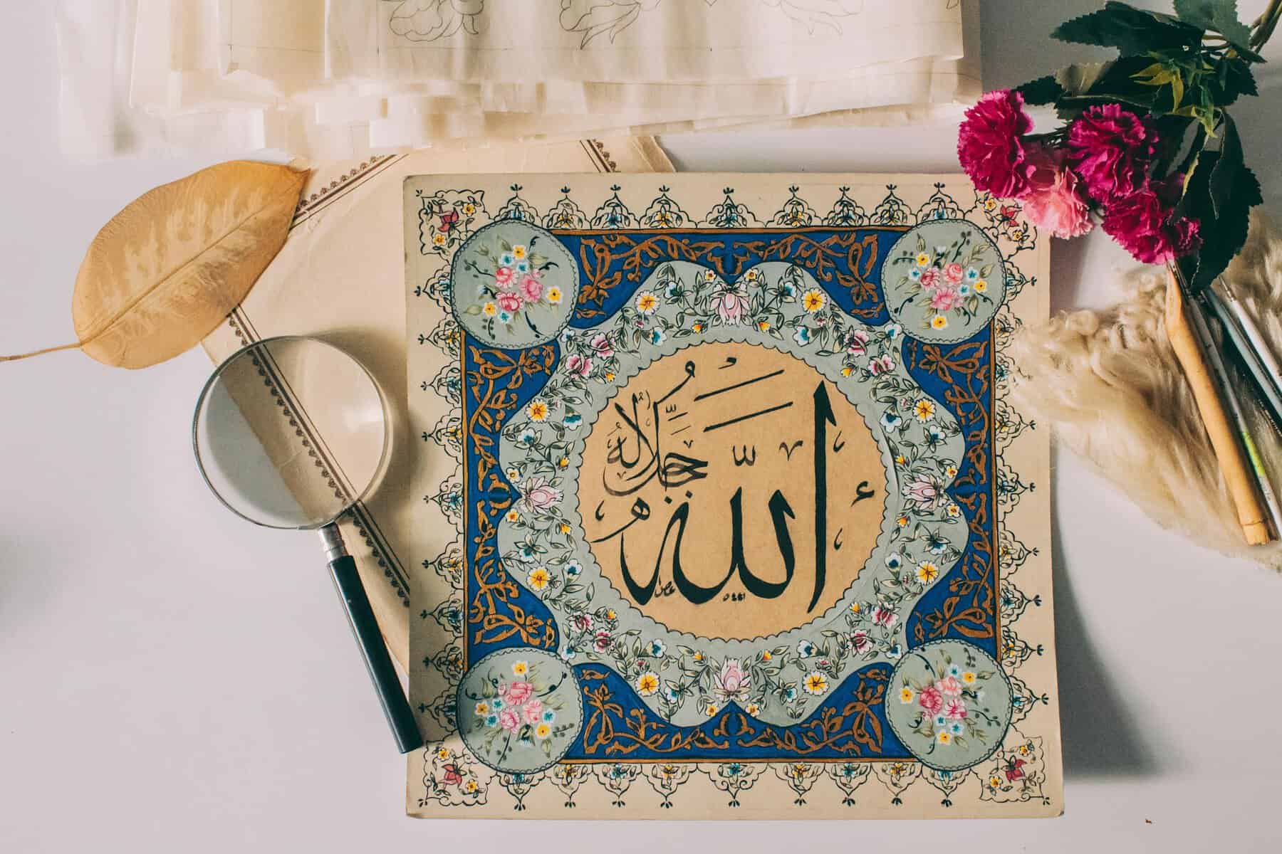 Hand-illuminated Arabic calligraphy showing the name of Allah on a floral and geometric ornament with magnifying glass