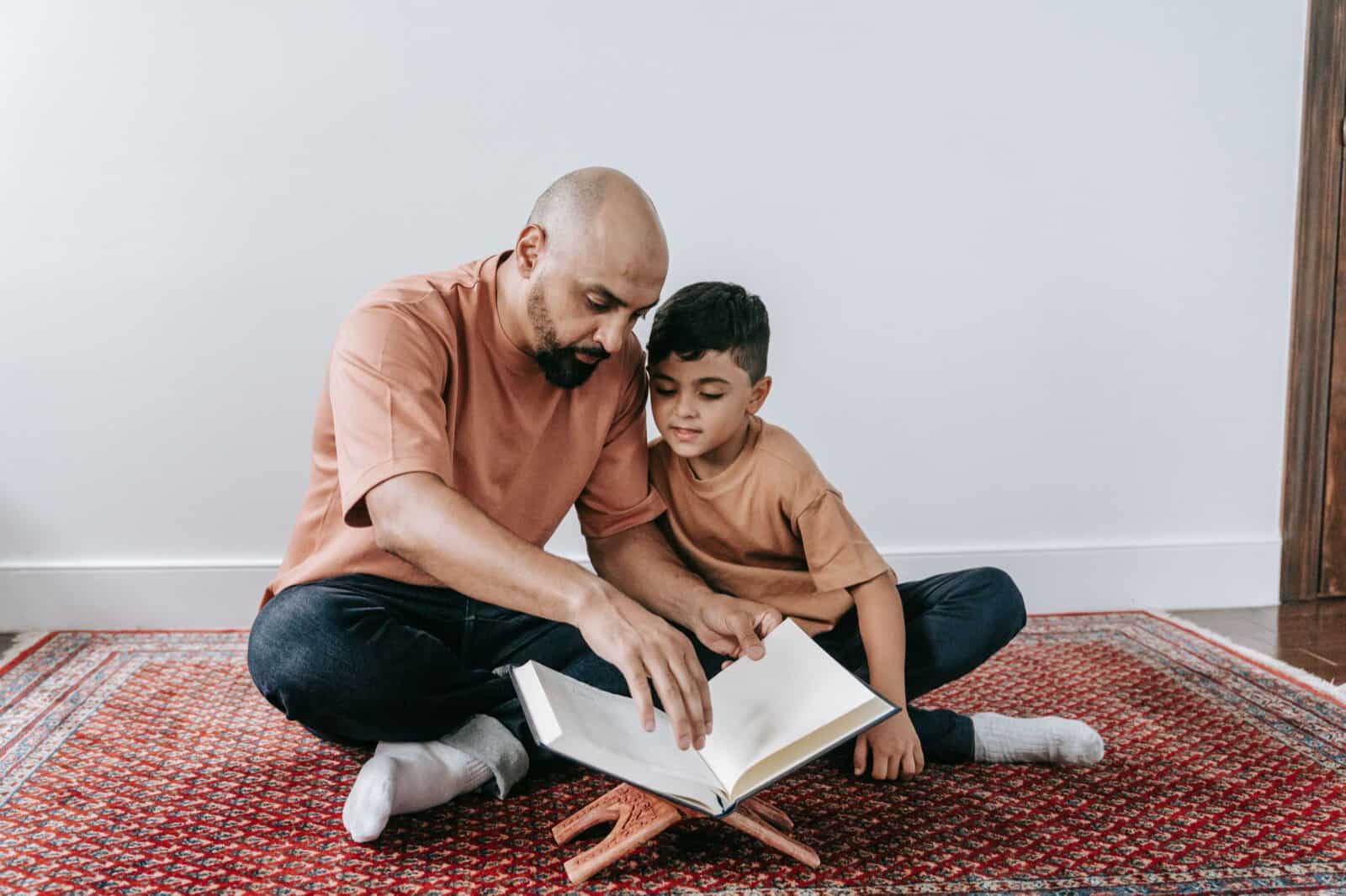 A father teaching his son to read the Quran from a wooden stand, the kind of guided reading a beginner course provides