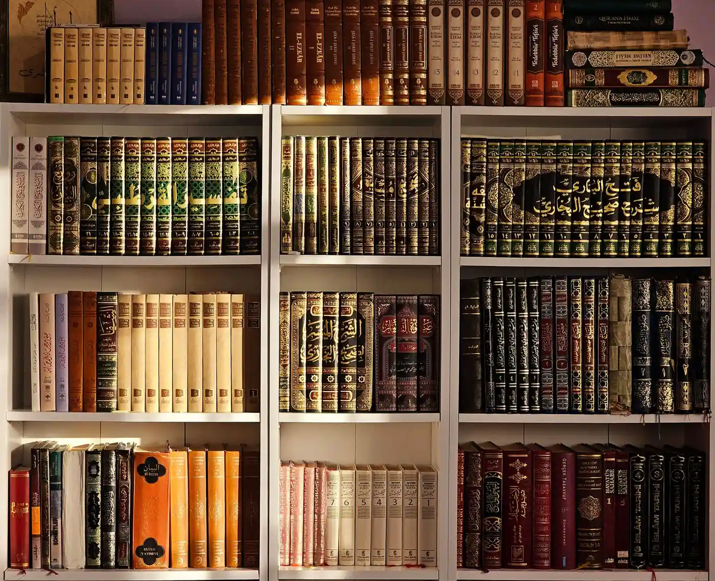 Shelves of multi-volume Arabic tafsir and hadith commentary sets in an Islamic library