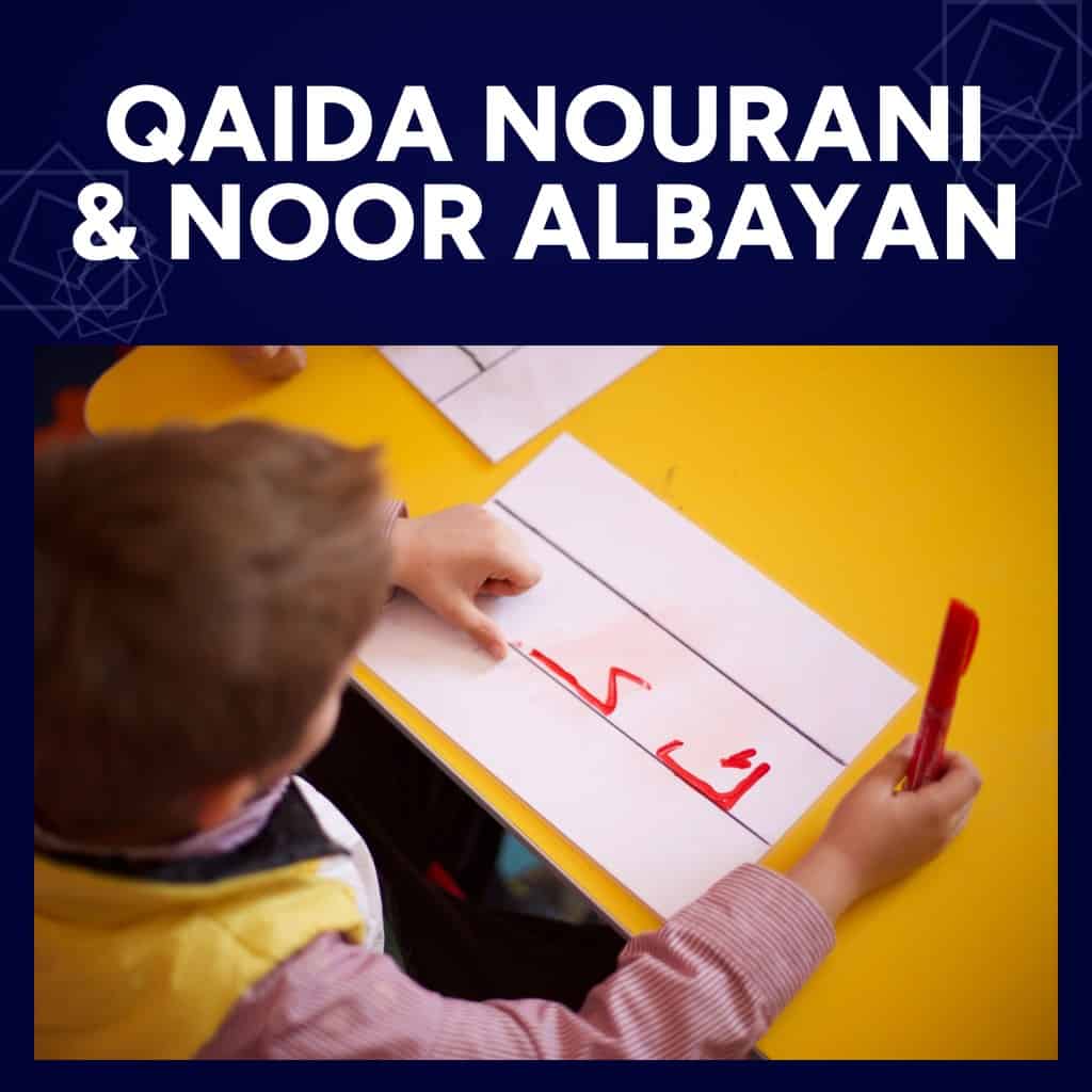 Qaida Noorani and Noor Al-Bayan course: a young boy writing the Arabic letter kaf in red marker at a school desk